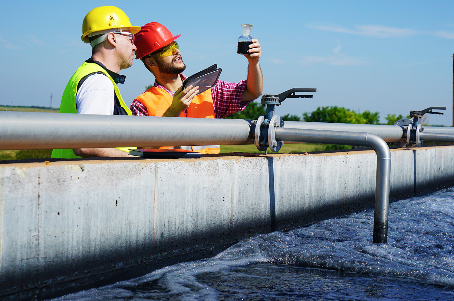 Engineers controlling quality of water at a waste water treatment plant